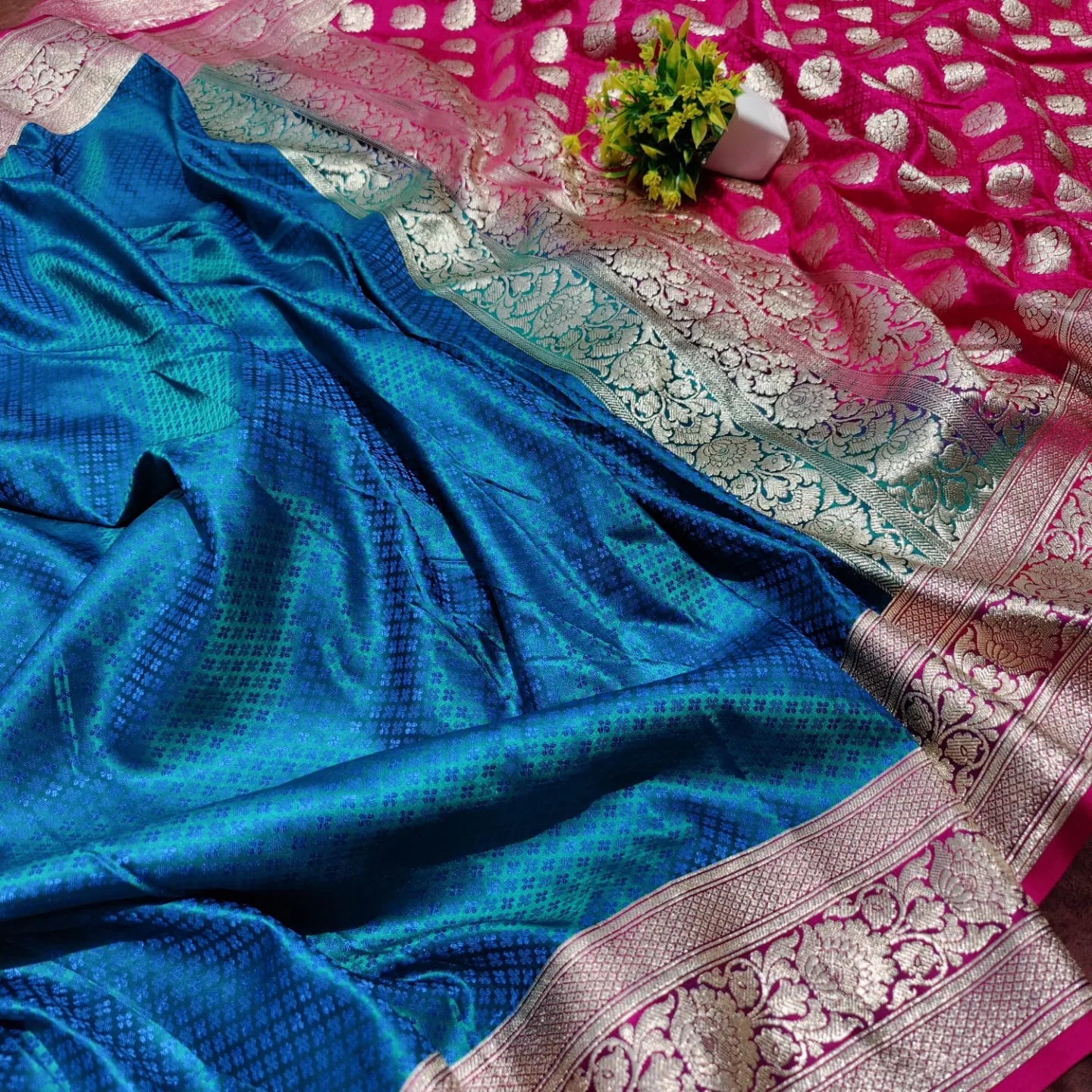 Rani ,blue patli saree woven work - Banarsi Brides
A luxurious Banarasi silk saree displayed on a mannequin, featuring a rich combination of pink, blue, and gold tones. The saree is adorned with intricate gold zari weaving in traditional floral and geometric patterns, with a broad golden border adding elegance. The vibrant color gradient enhances its beauty, making it perfect for festive and wedding occasions.