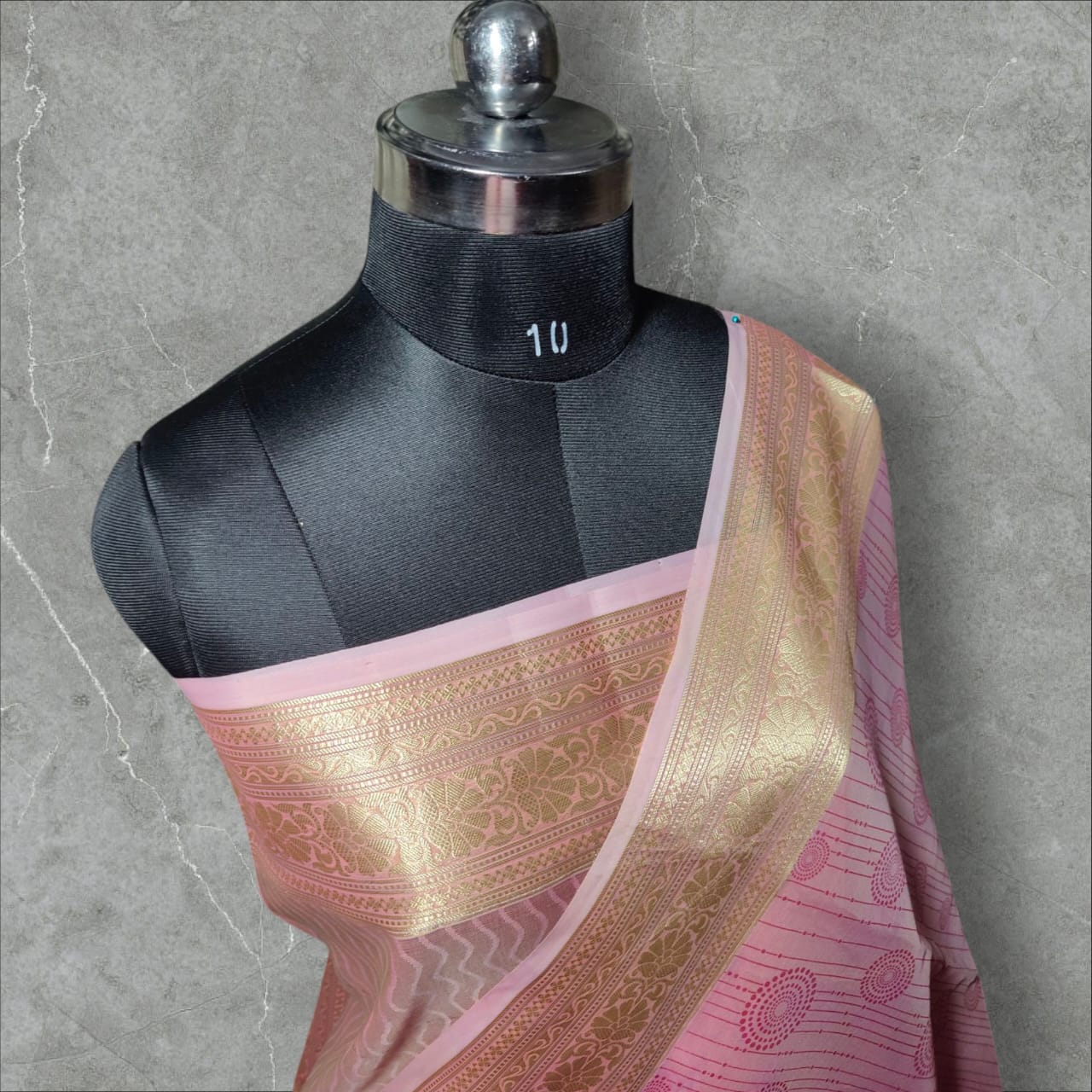 A beautiful organza silk saree in a soft pink color, featuring a lightweight, sheer texture with a subtle sheen. The saree drapes gracefully, adding an elegant and ethereal charm, perfect for weddings, festive occasions, and special events.