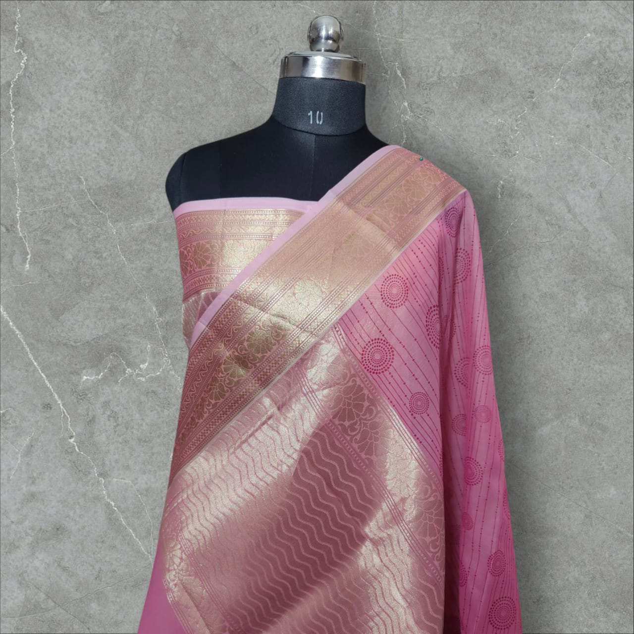 A beautiful organza silk saree in a soft pink color, featuring a lightweight, sheer texture with a subtle sheen. The saree drapes gracefully, adding an elegant and ethereal charm, perfect for weddings, festive occasions, and special events.